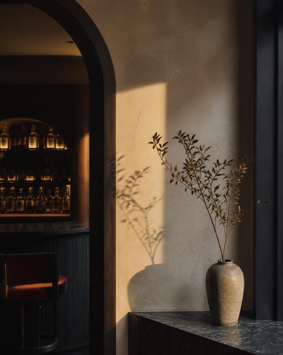 Golden hour light falling across a boutique hotel bar and plaster wall